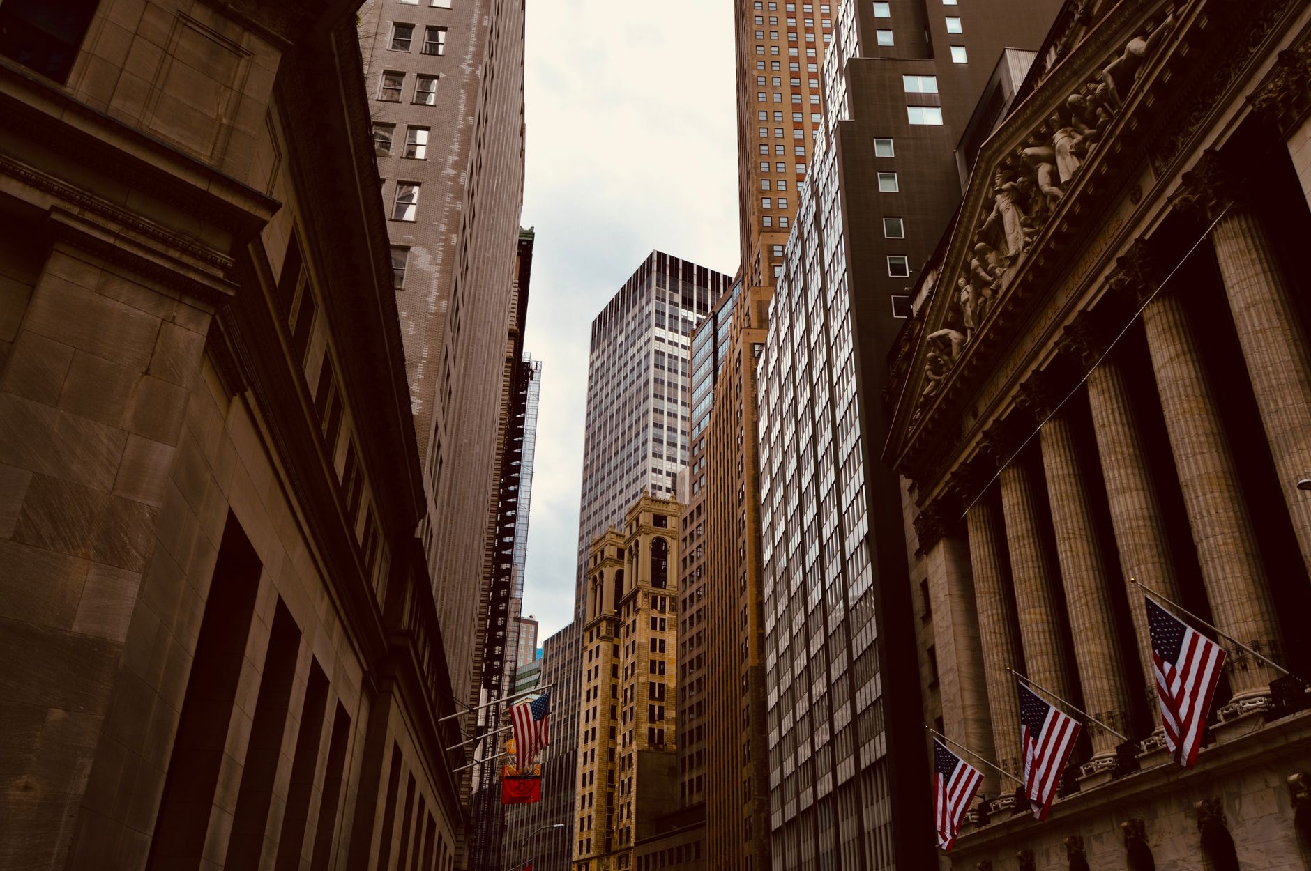 Edificios del distrito financiero de Nueva York con banderas estadounidenses sobre la acera