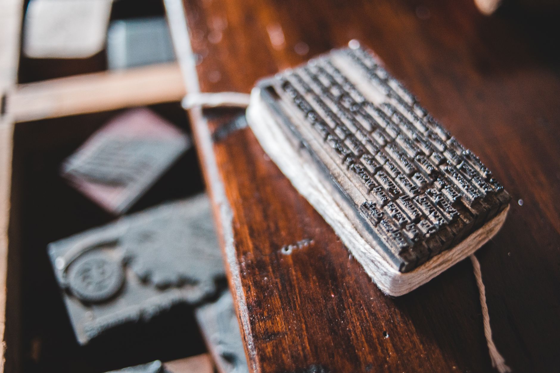 Bloque de tipos de imprenta de metal atado con cordel sobre un escritorio de madera en un taller