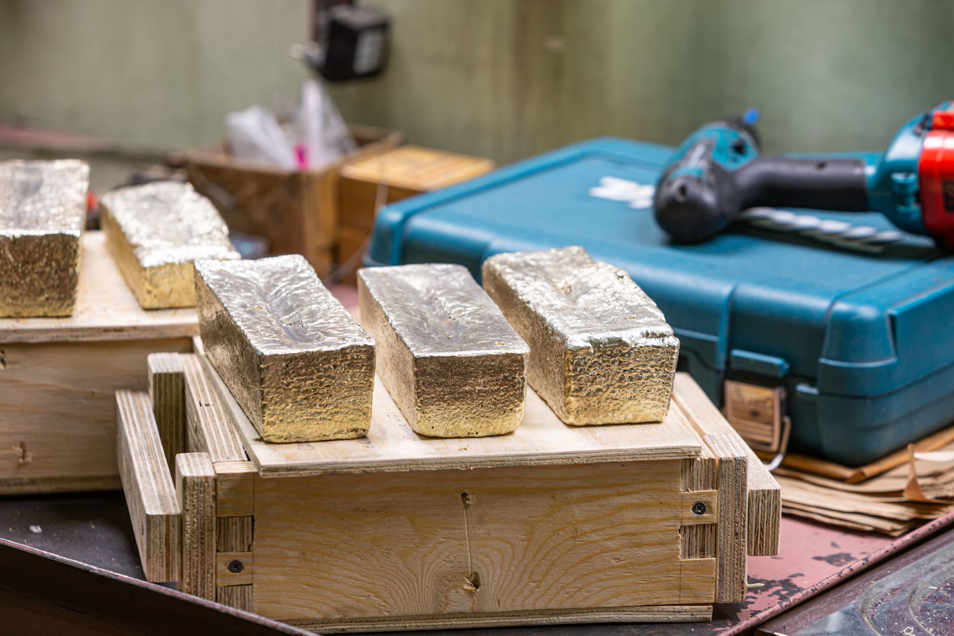 Lingotes de oro recién fundidos sobre cajas de madera en el taller de una refinería