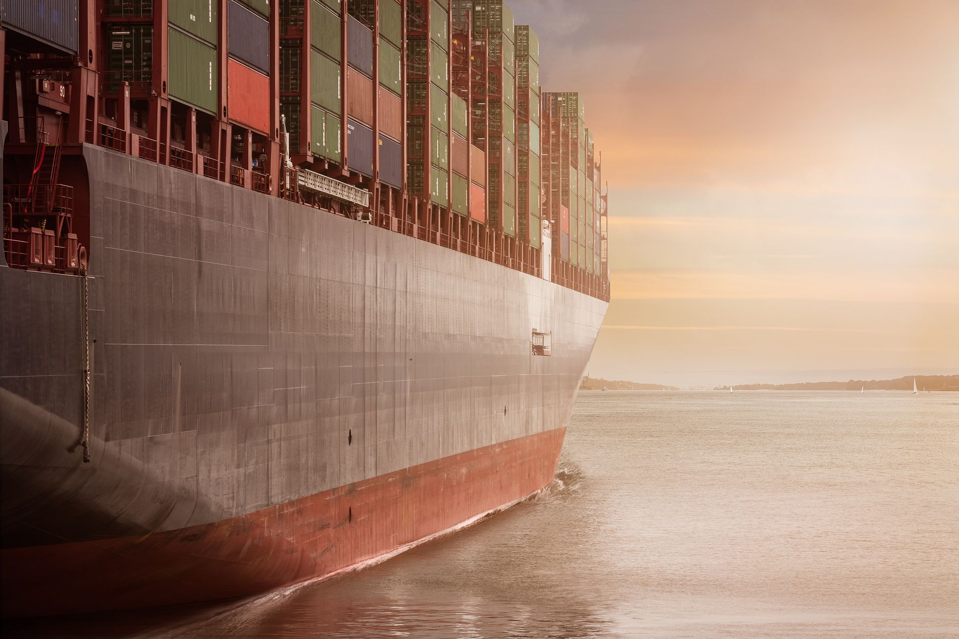 Buque portacontenedores cargado navegando al atardecer con luz cálida