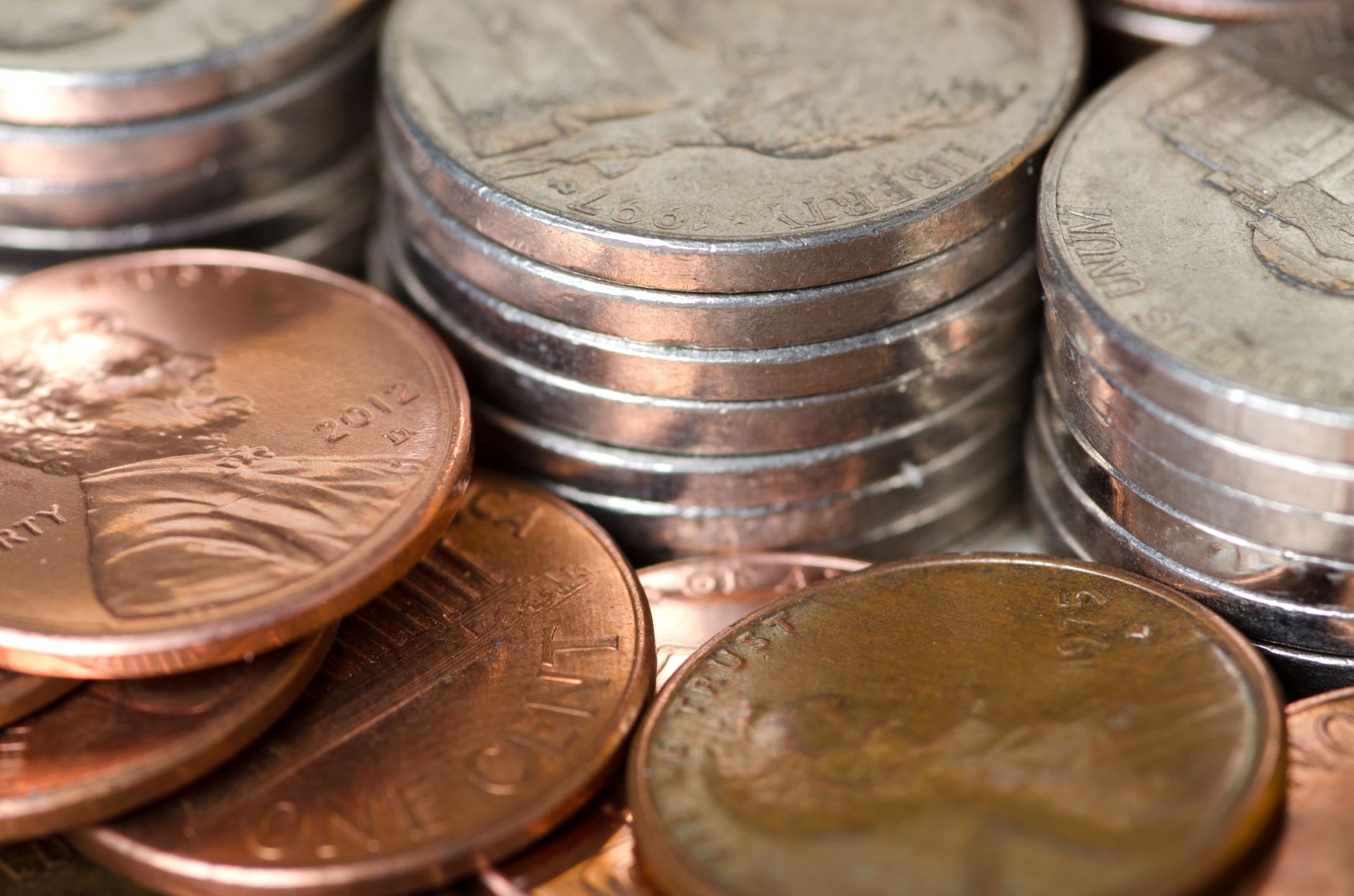 Monedas estadounidenses agrupadas en montones separados de distinta altura sobre una mesa