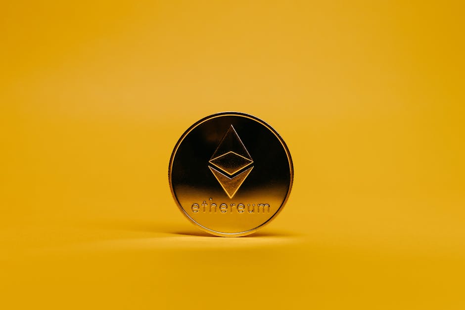 Moneda de Ethereum dorada con su símbolo en relieve, de pie sobre un fondo amarillo liso