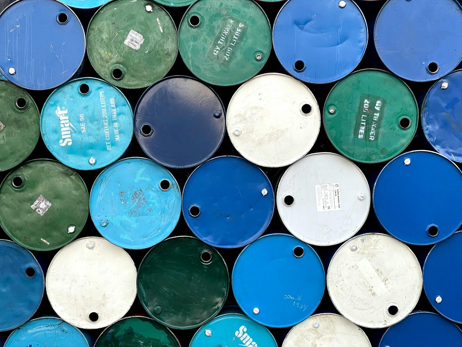 Barriles metálicos industriales de 200 litros apilados, con inscripciones como Smart y GY Thinner visibles