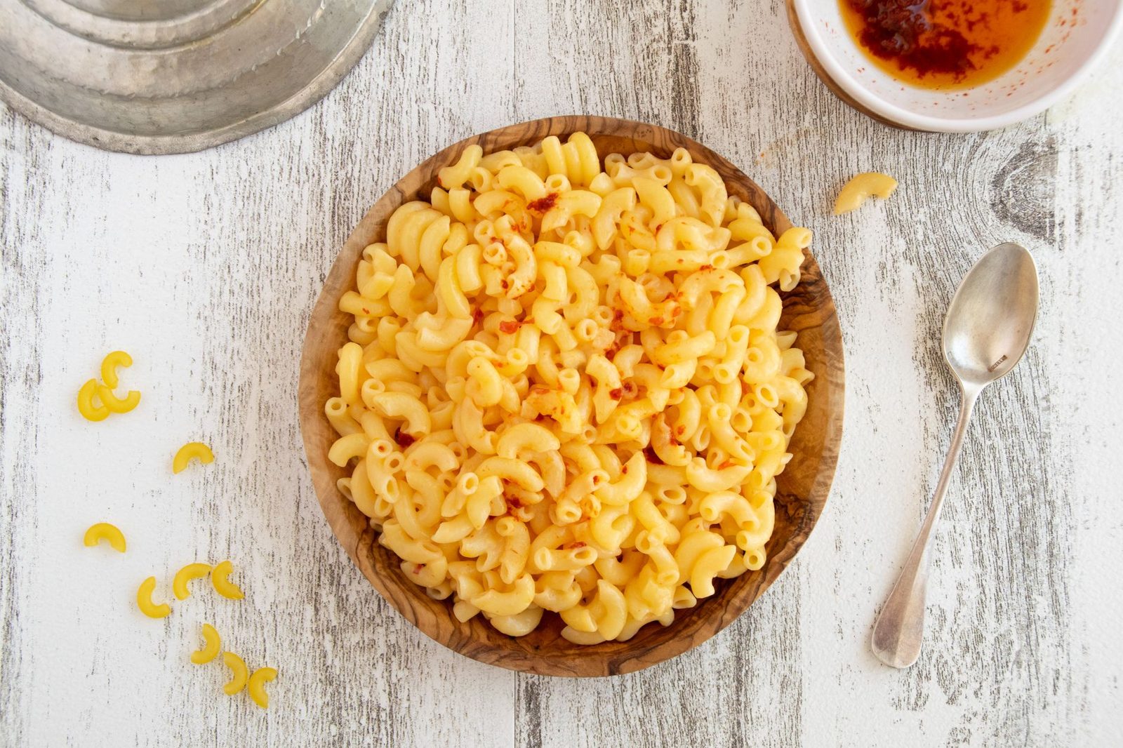 Macarrones cortos en salsa de queso espolvoreados con pimentón, servidos en un cuenco de madera