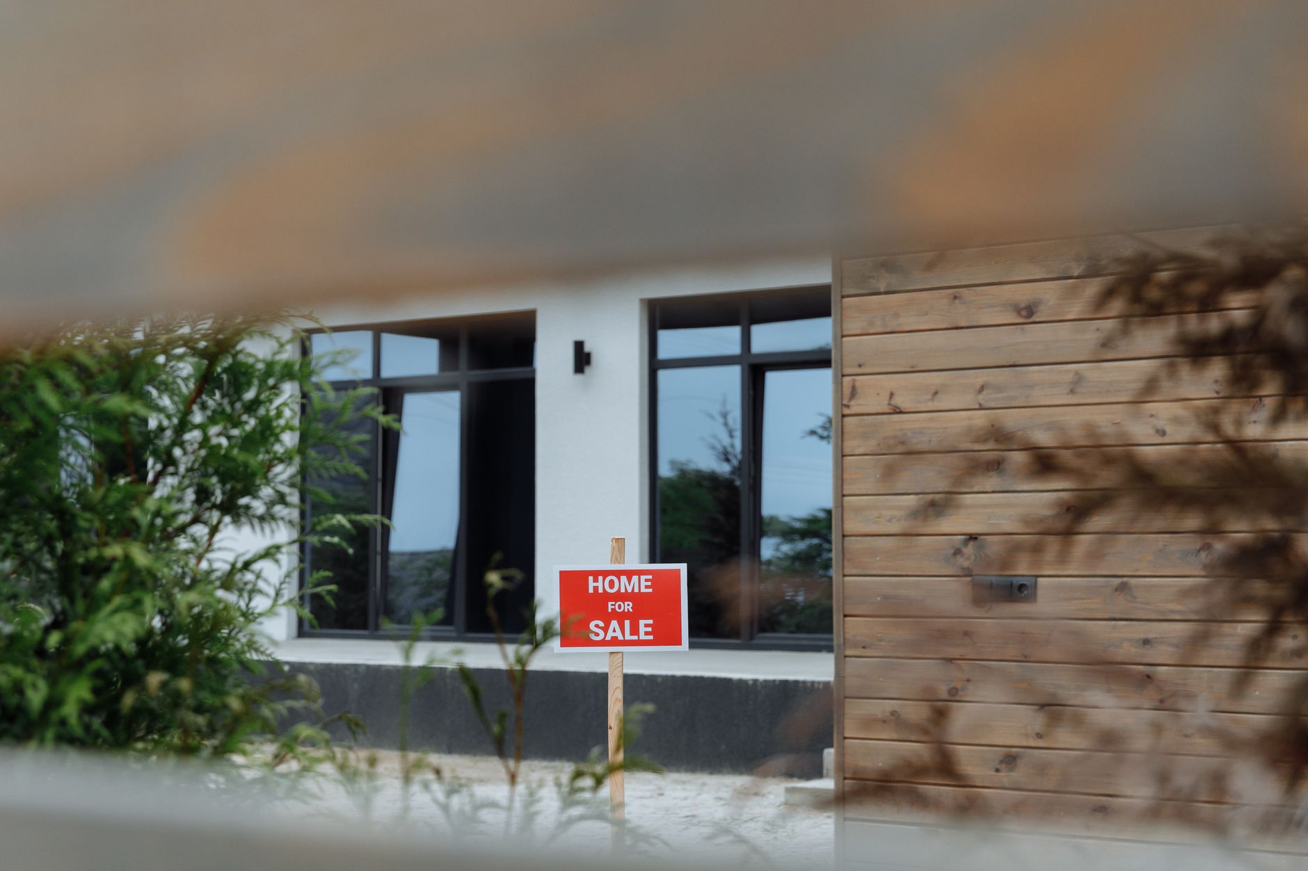 Cartel de venta plantado en el jardín de una casa que sigue esperando comprador