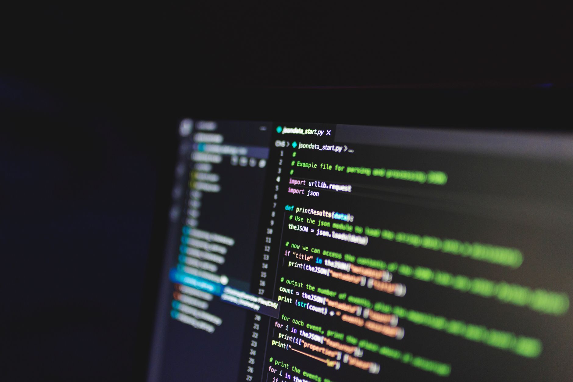 Pantalla de un editor de código con líneas de programación iluminadas en una habitación a oscuras